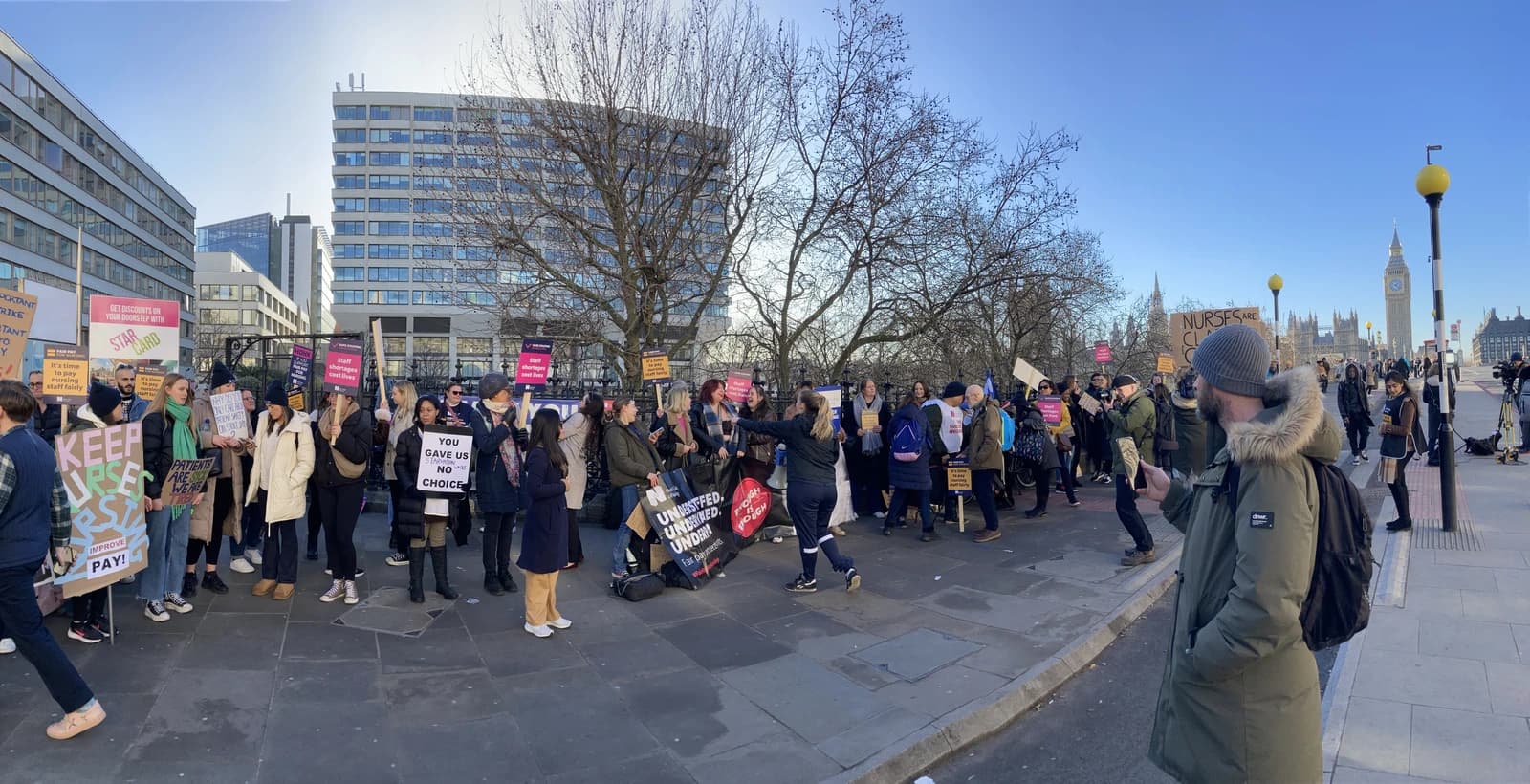 Protestors gathered on a street in London, holding signs during an NHS demonstration.