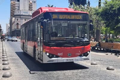 Red and white public transport bus in Santiago, Chile, on a city street.