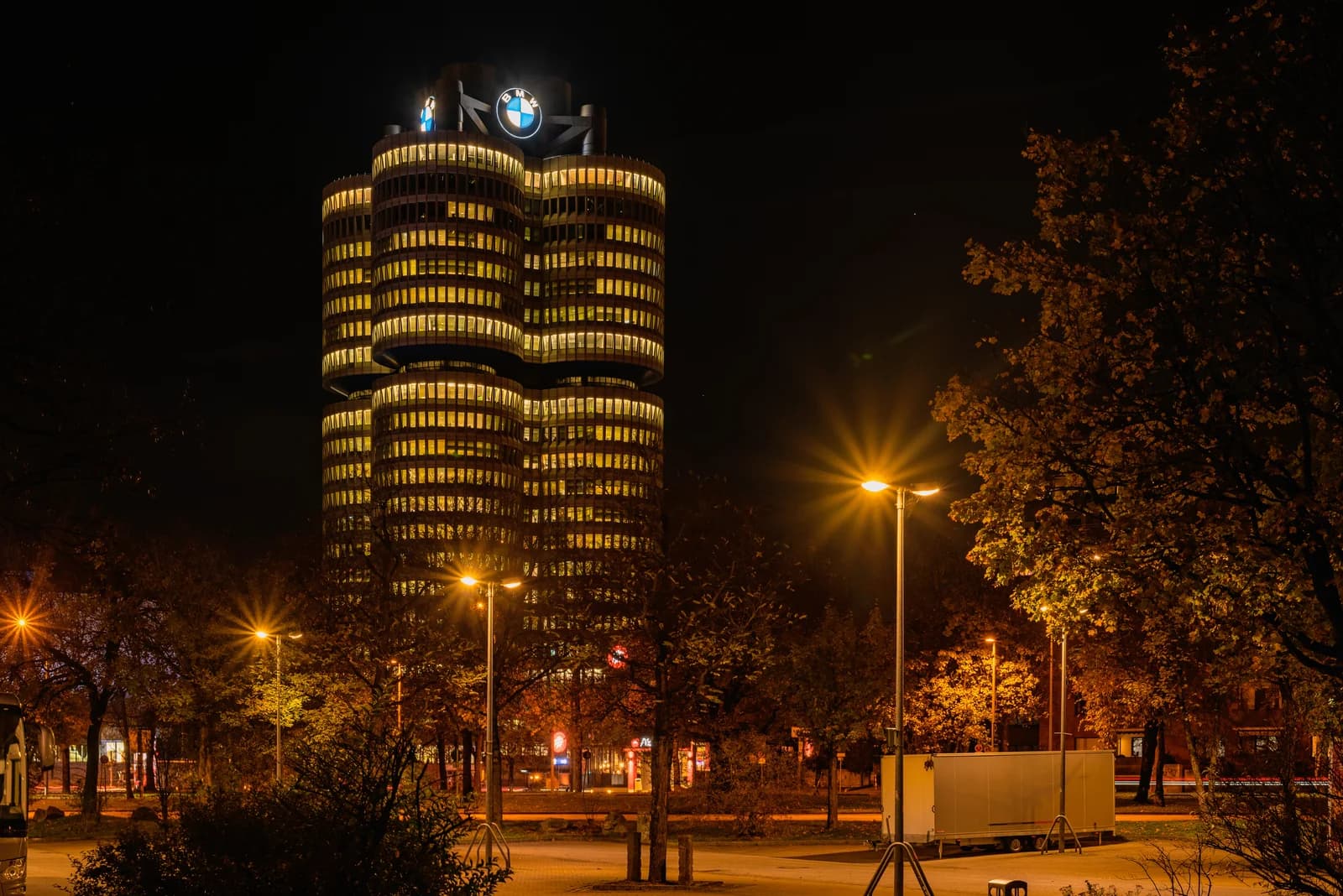 Illuminated BMW Tower headquarters building stands at night in Munich, Germany.