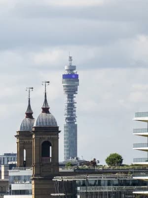 The BT Tower, a tall cylindrical structure, stands prominently against a cloudy sky.