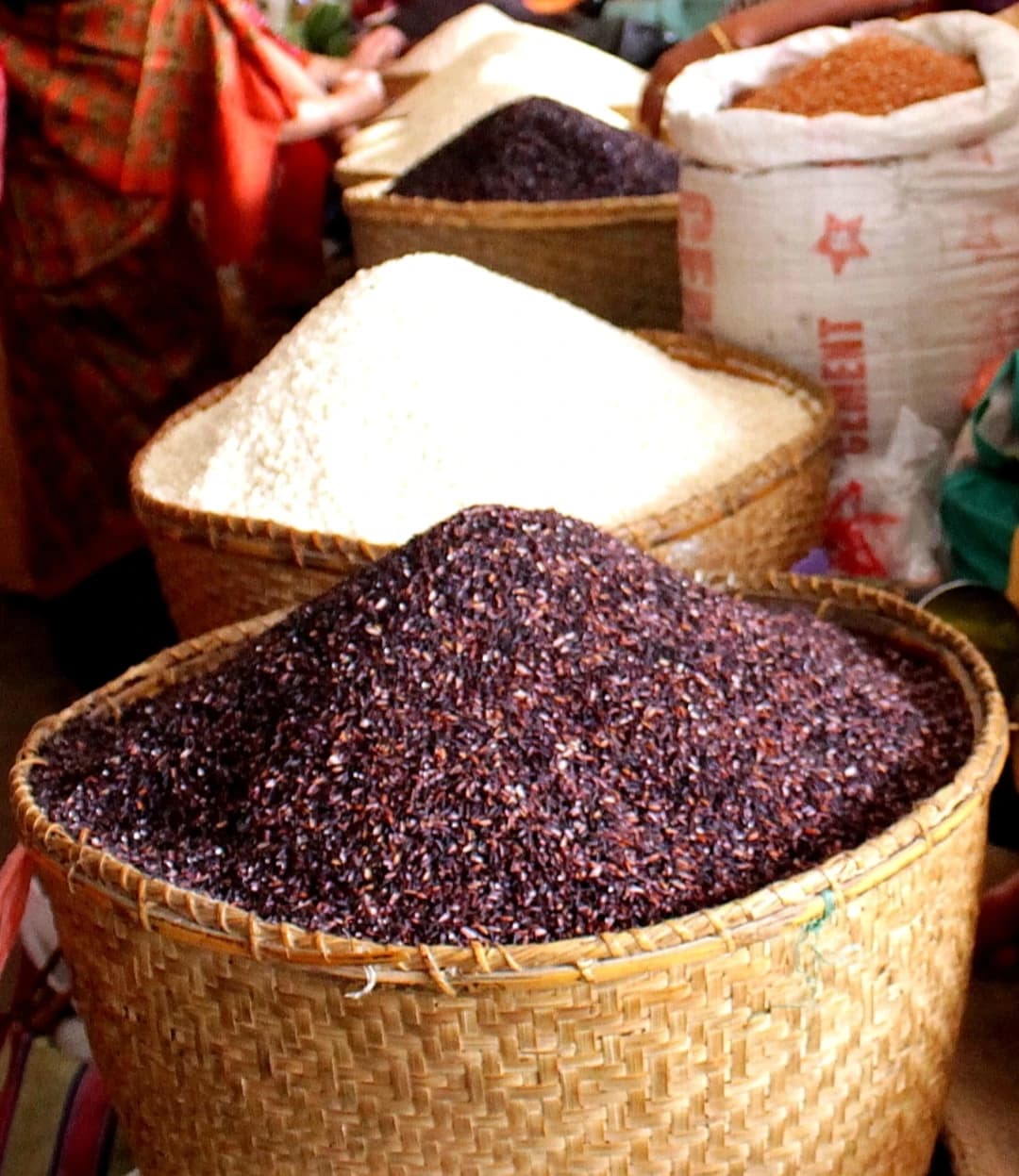 Chak-hao paddy and Meitei Cheng, traditional Indian rice varieties, displayed in baskets.