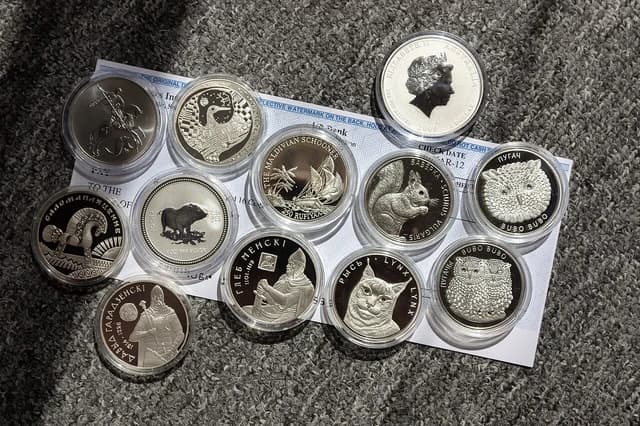 Collection of silver coins from different countries and with various designs.