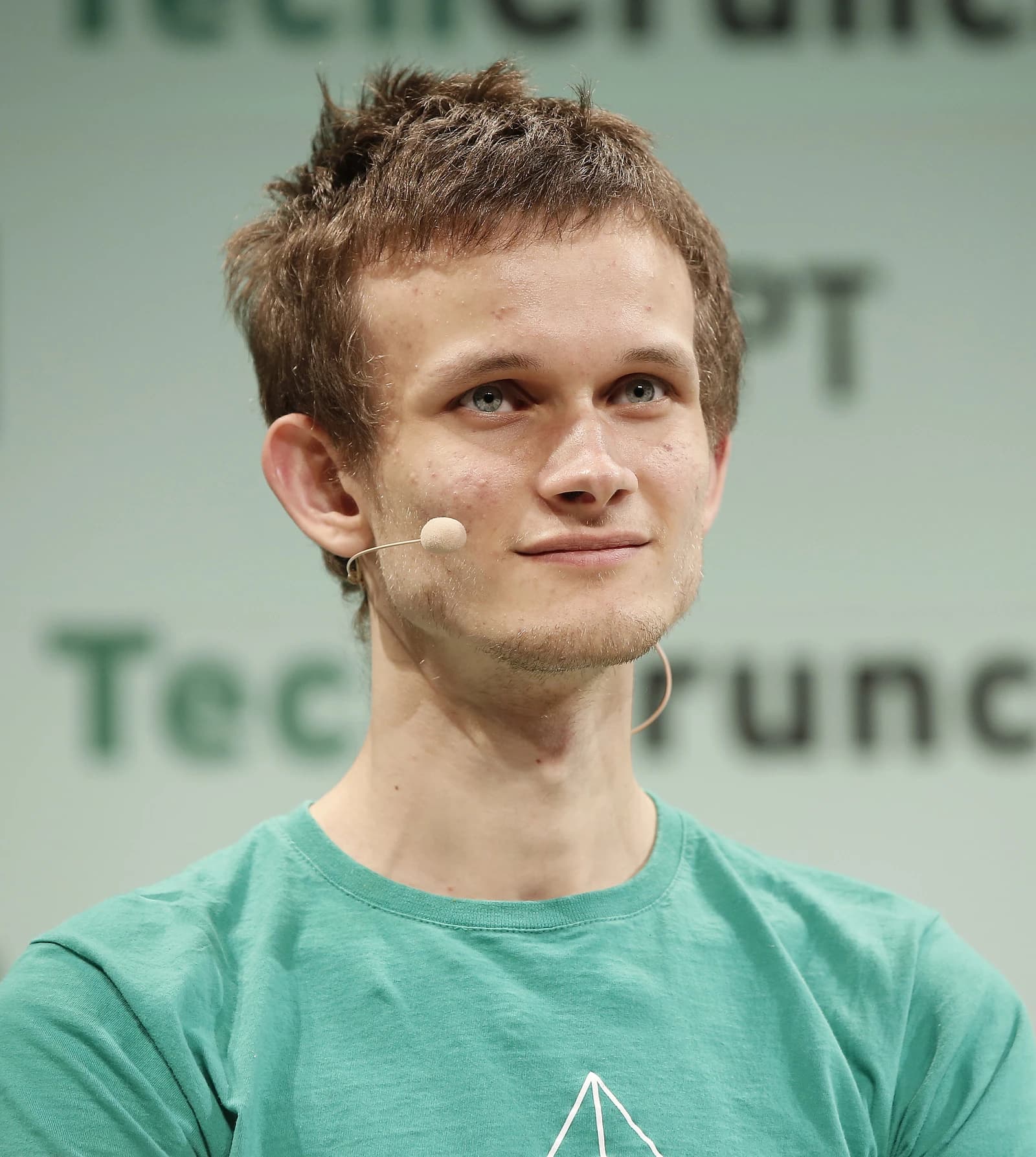 Vitalik Buterin, co-founder of Ethereum, speaking into a microphone at an event.