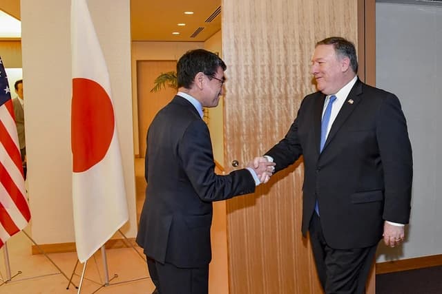Secretary of State Mike Pompeo shakes hands with Japanese Foreign Minister Taro Kono.