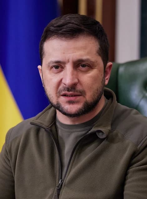Ukrainian President Volodymyr Zelenskyy speaks during an address in an office setting.