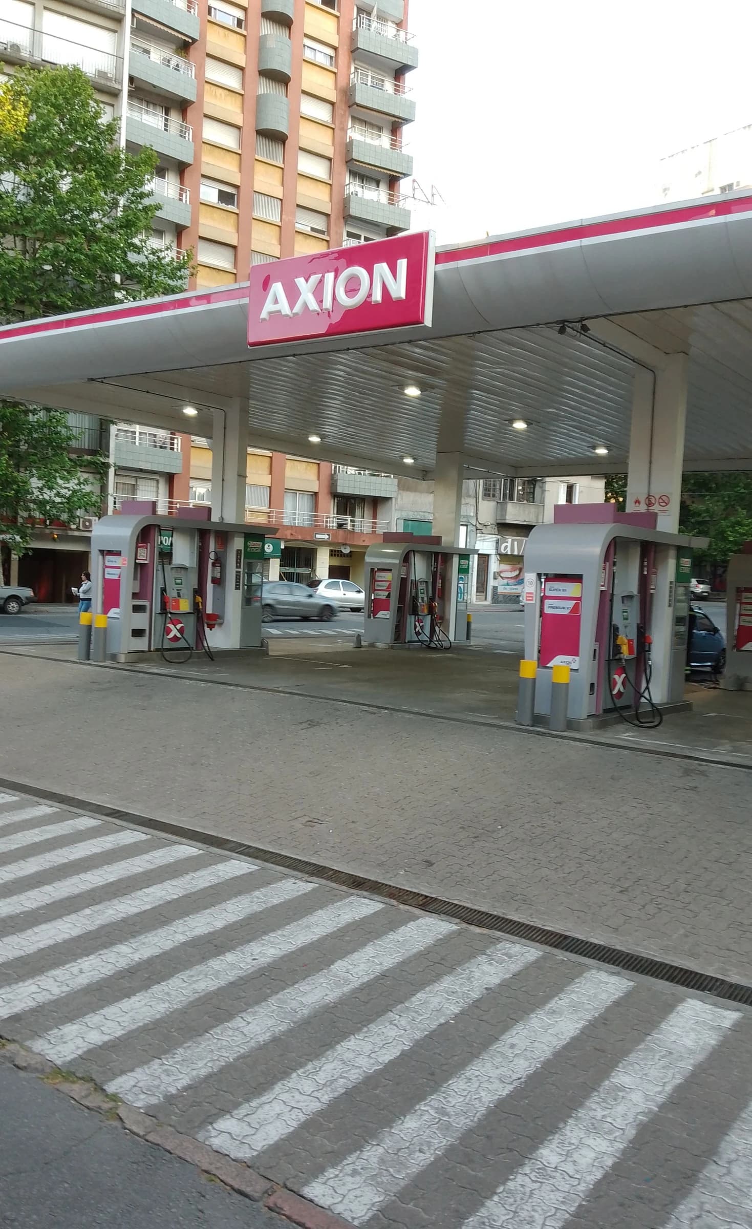 Exterior view of an Axion Energy gas station showing pumps and canopy in Montevideo.