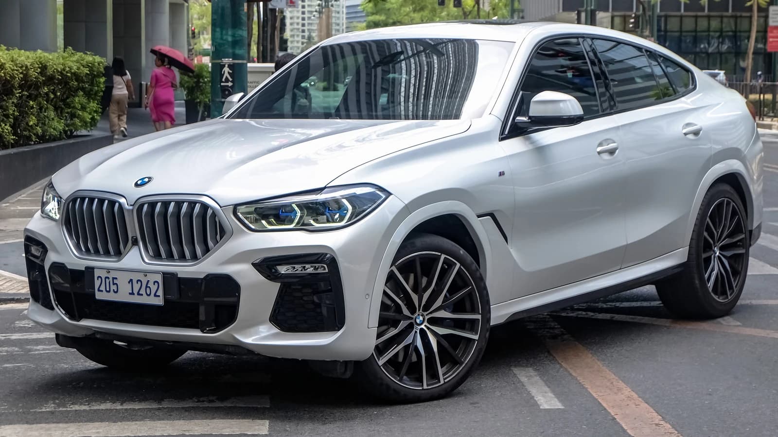 White BMW X6 G06 xDrive30d M Sport Package parked on a city street.