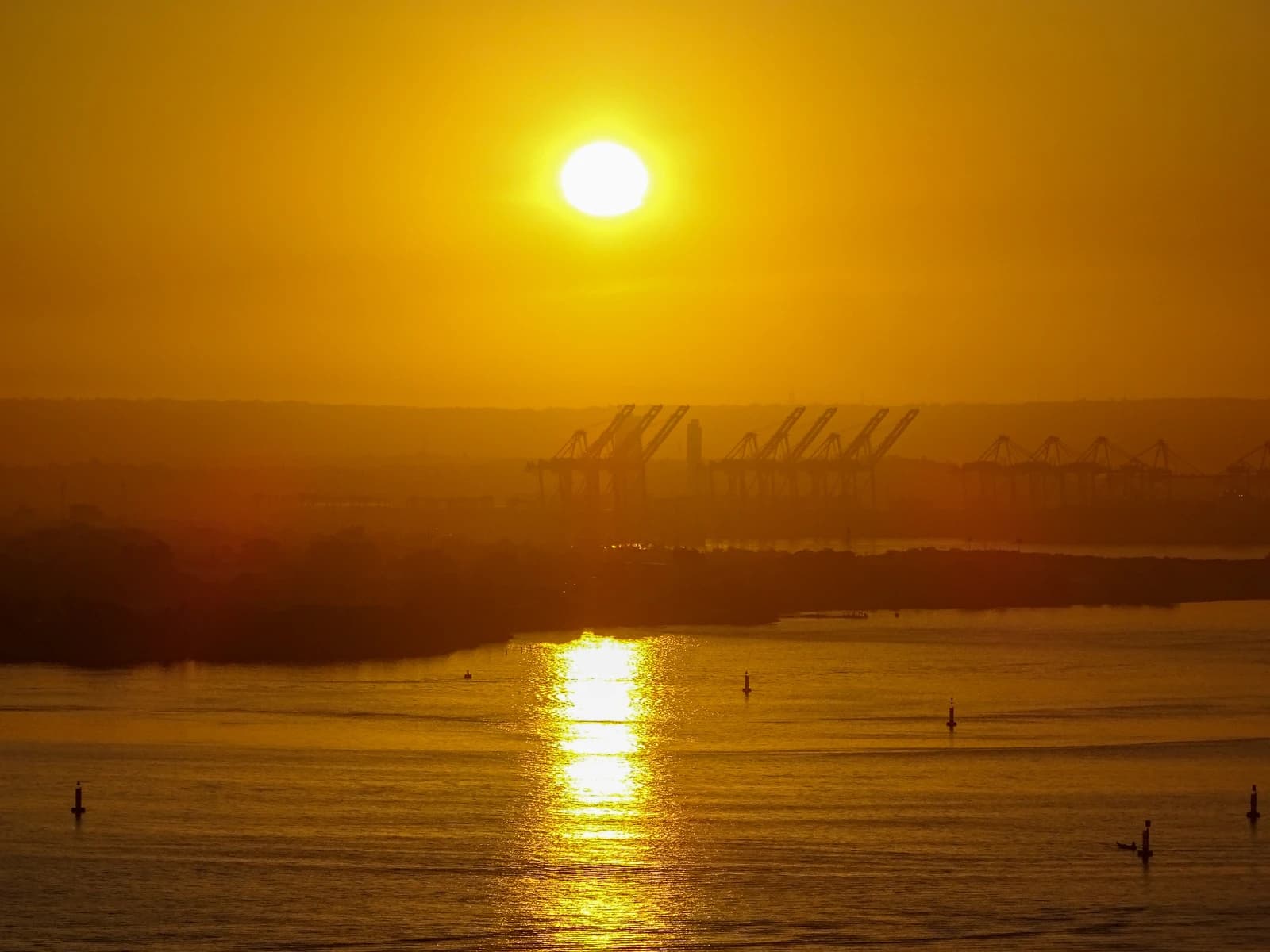 Commercial port of Cartagena de Indias, Colombia, with cargo cranes at sunrise.