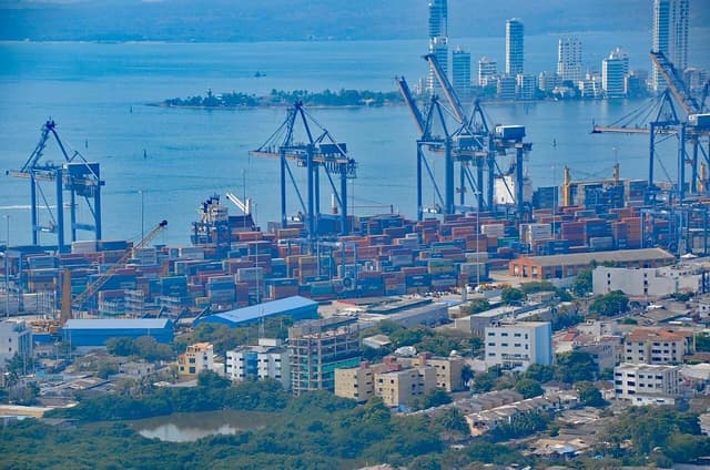 Aerial view of a busy container port in Cartagena, Colombia, with ships and cranes.