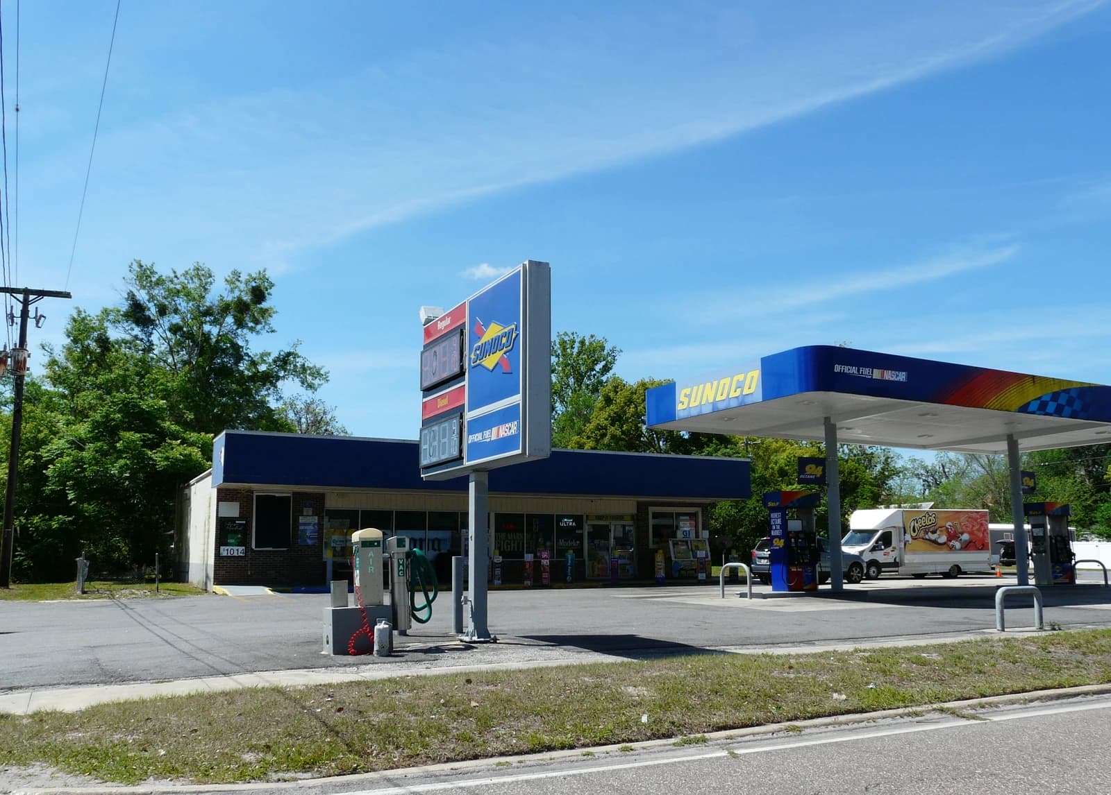 A Sunoco gas station with a large sign displaying fuel prices.