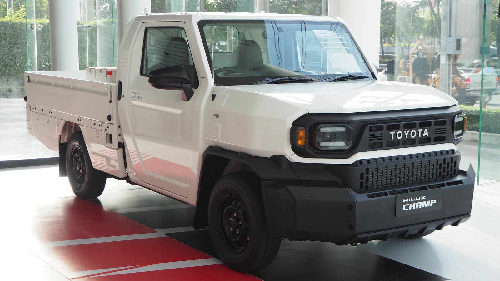 White 2023 Toyota Hilux Champ 2.4 Diesel pickup truck in a showroom.