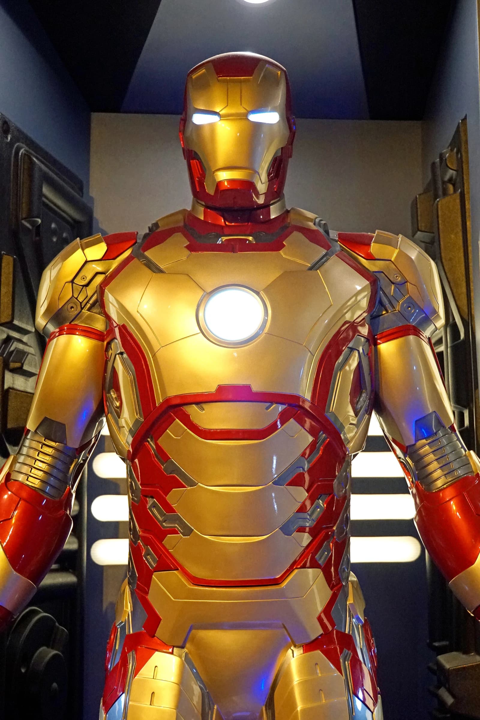 Iron Man armor display with glowing arc reactor and eyes.