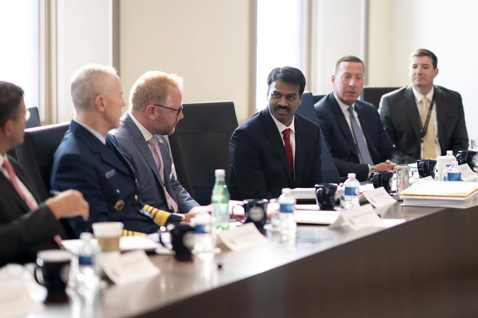 Group of Department of Homeland Security officials seated at a conference table during a meeting.