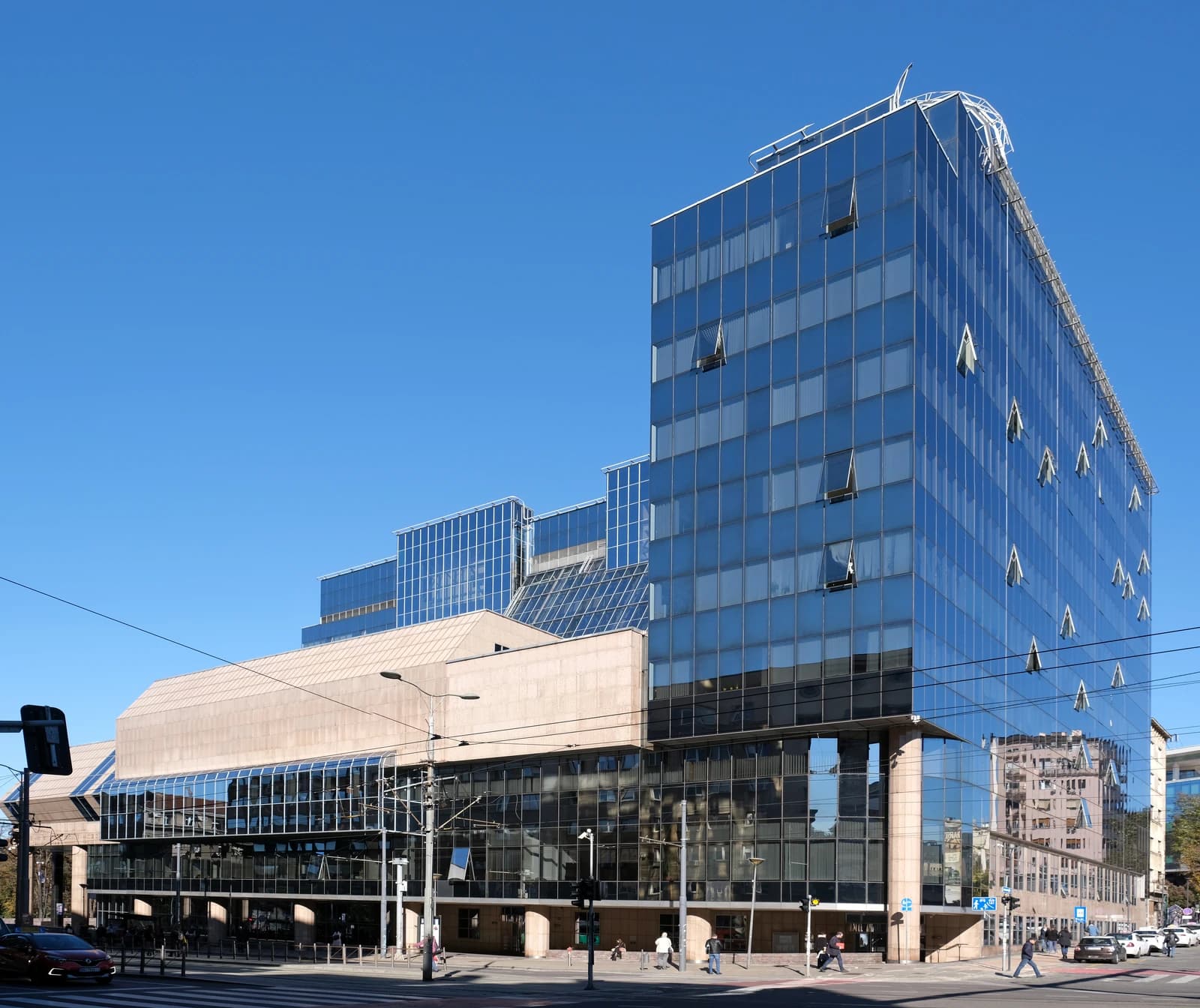 National Bank of Serbia building, a modern glass and stone structure, under a clear blue sky.