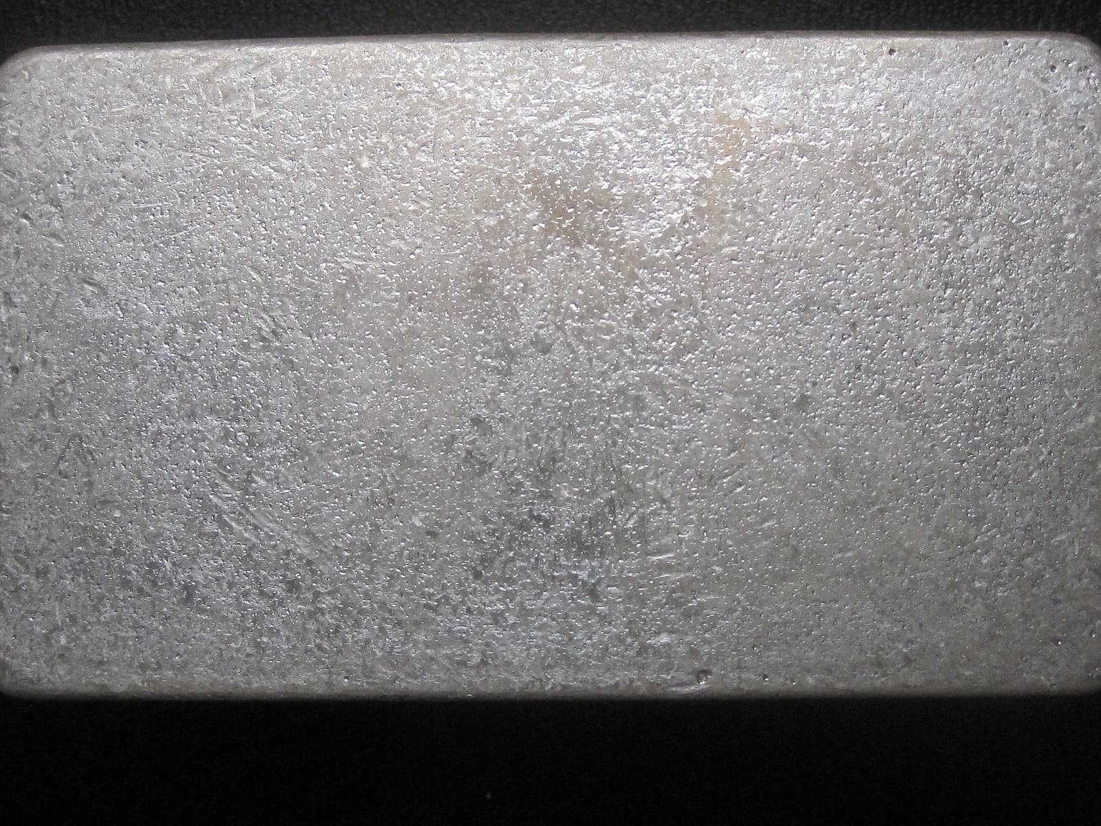 Textured surface of a silver bullion bar, possibly from Rusty's Bullion Bar.