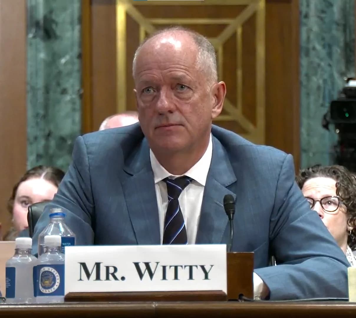 Andrew Witty, CEO of UnitedHealth Group, sitting at a table during a hearing.