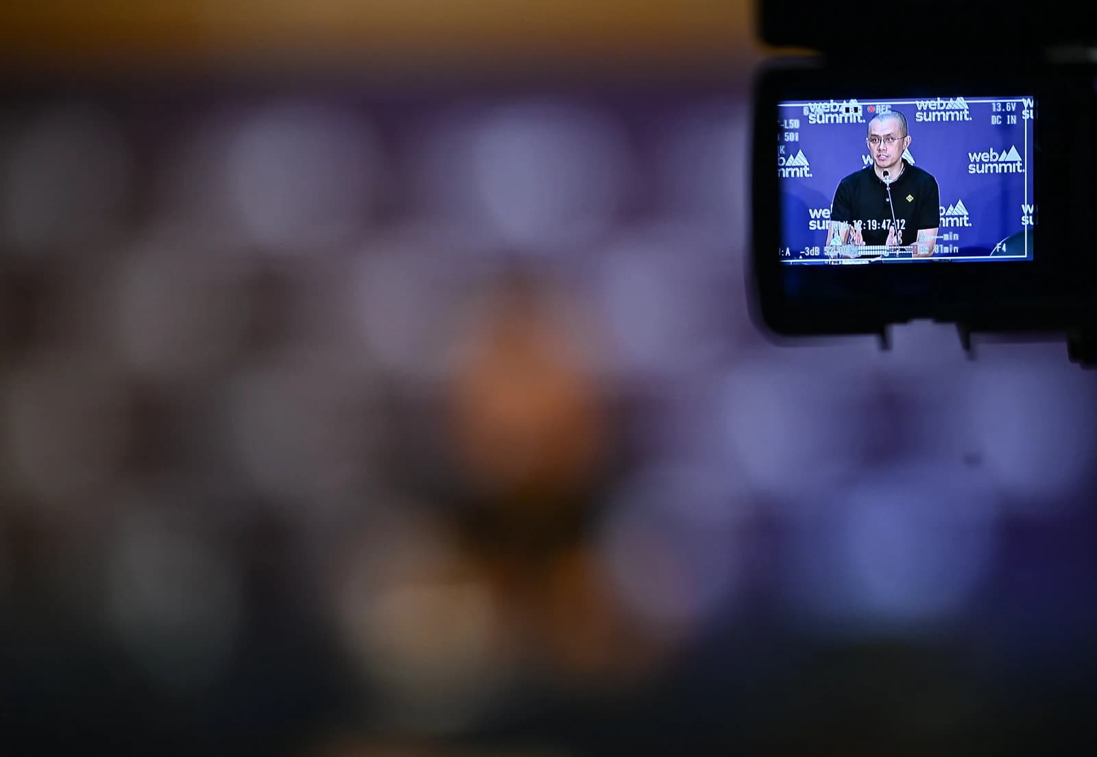 Changpeng Zhao, CEO of Binance, speaks at a podium during a conference.