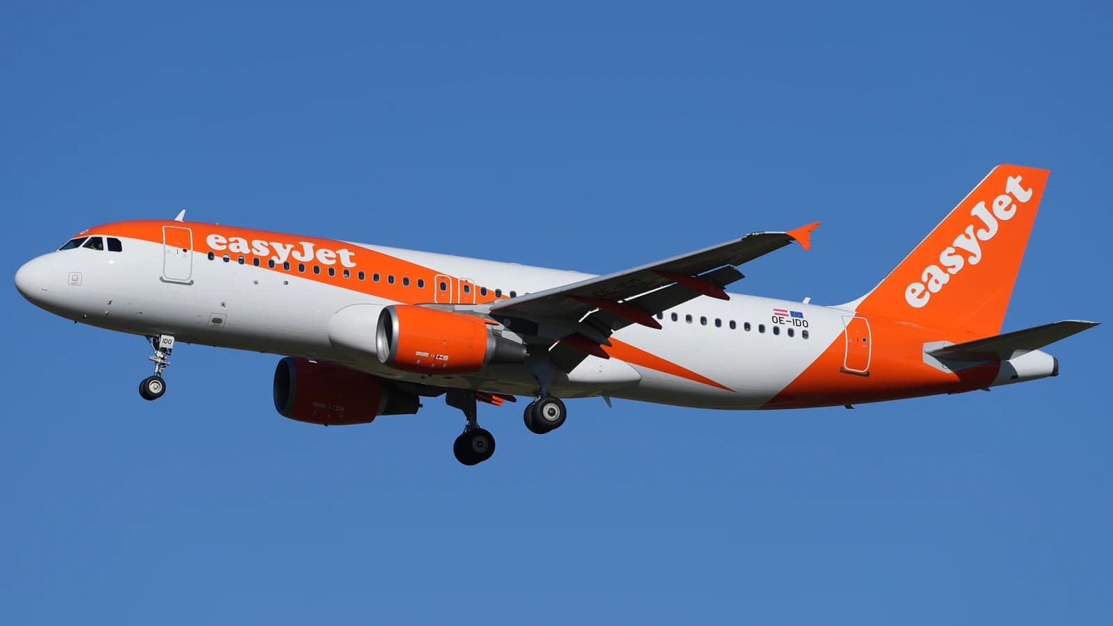 An easyJet Europe Airbus A320-214 airplane, registration OE-IDO, flying in a blue sky.