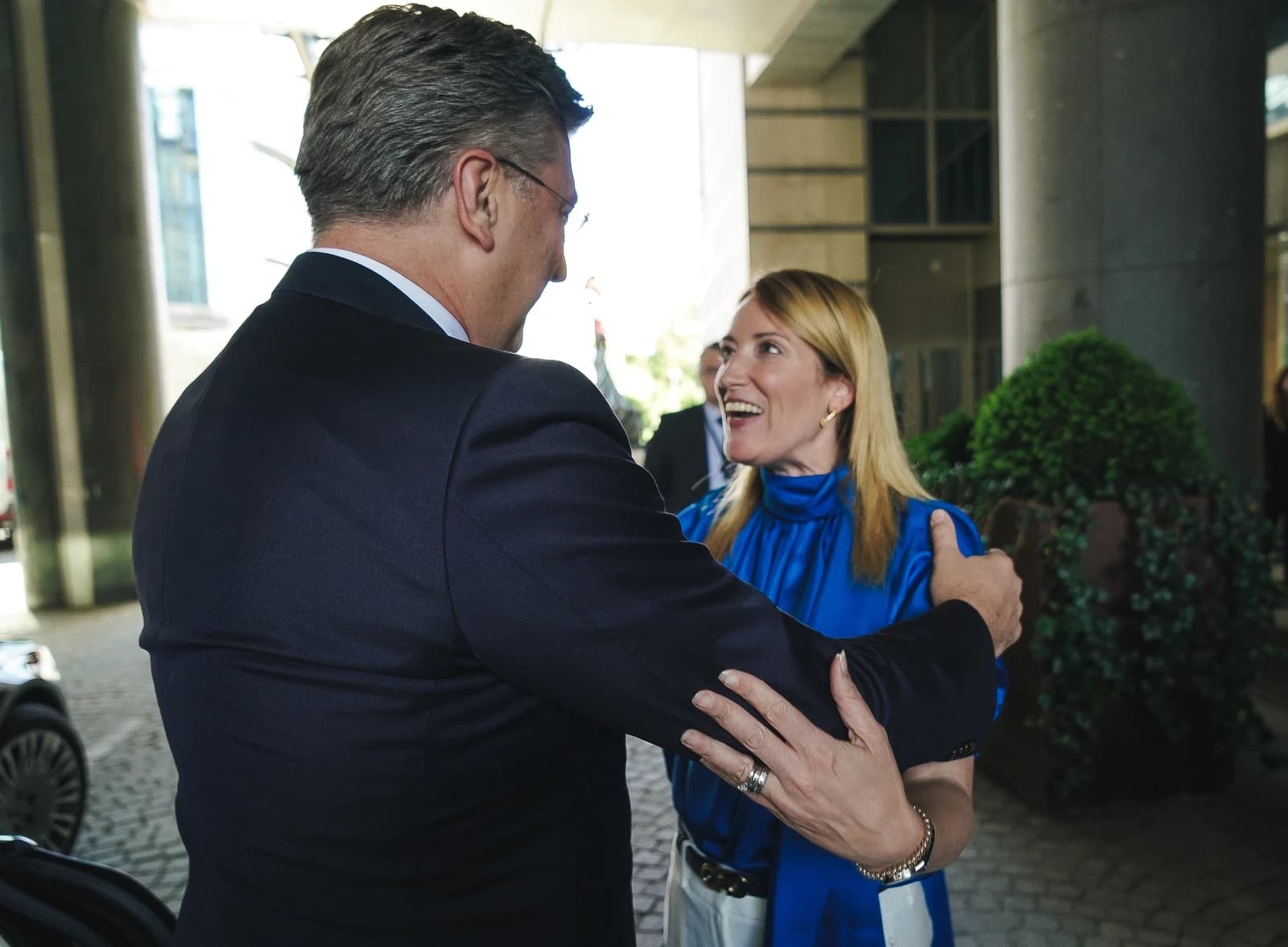 Andrej Plenković, Prime Minister of Croatia, speaking with a woman outdoors.