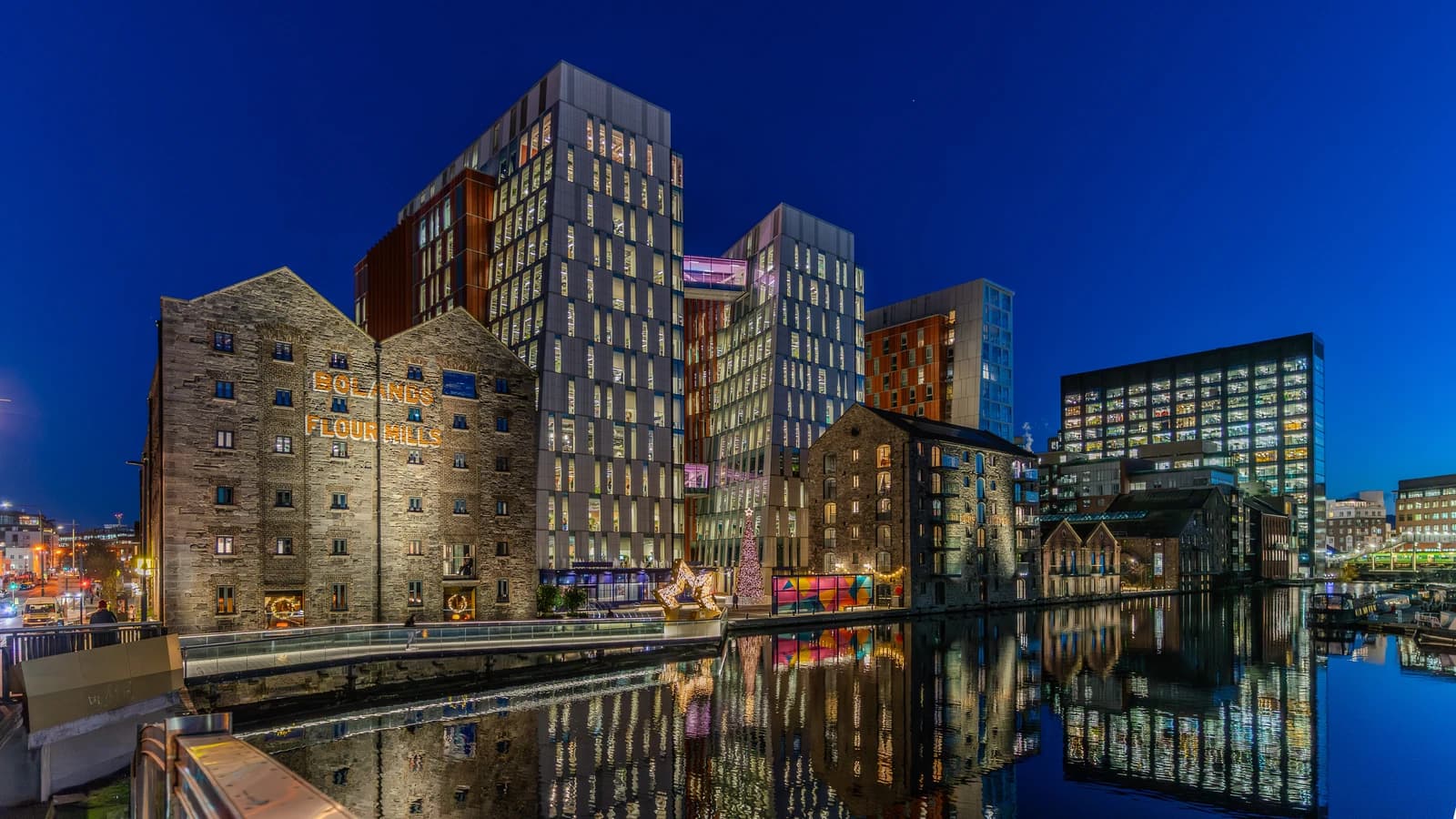 Boland's Mill, a historic and redeveloped area, illuminated at night along a canal.