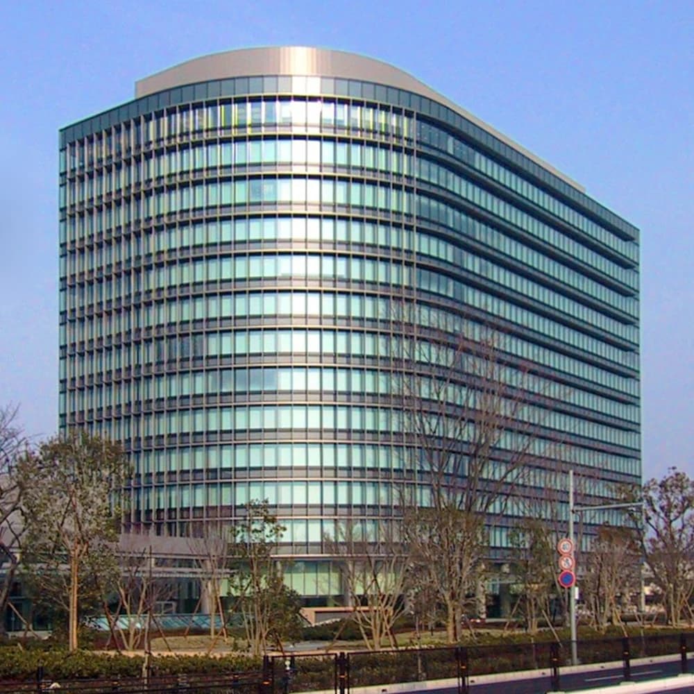 Toyota Motor Corporation headquarters building, a large curved glass and steel structure.