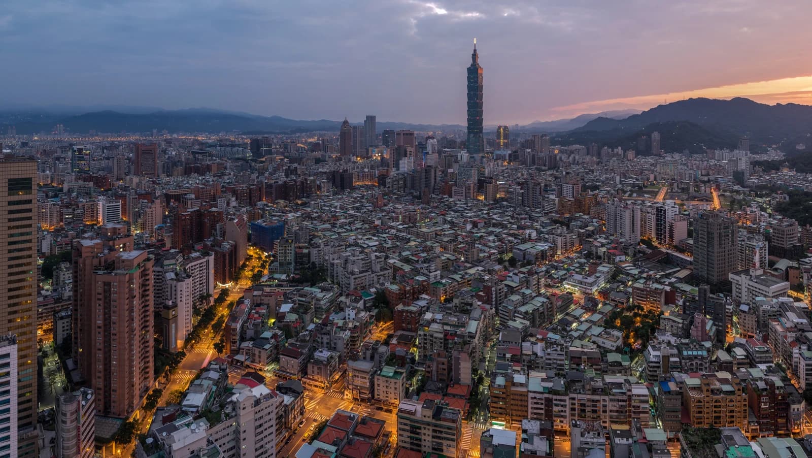 Taipei 101 skyscraper dominates the cityscape of Taipei, Taiwan at dusk.