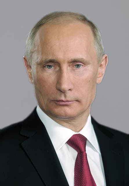Vladimir Putin, President of Russia, in a formal headshot against a plain grey background.