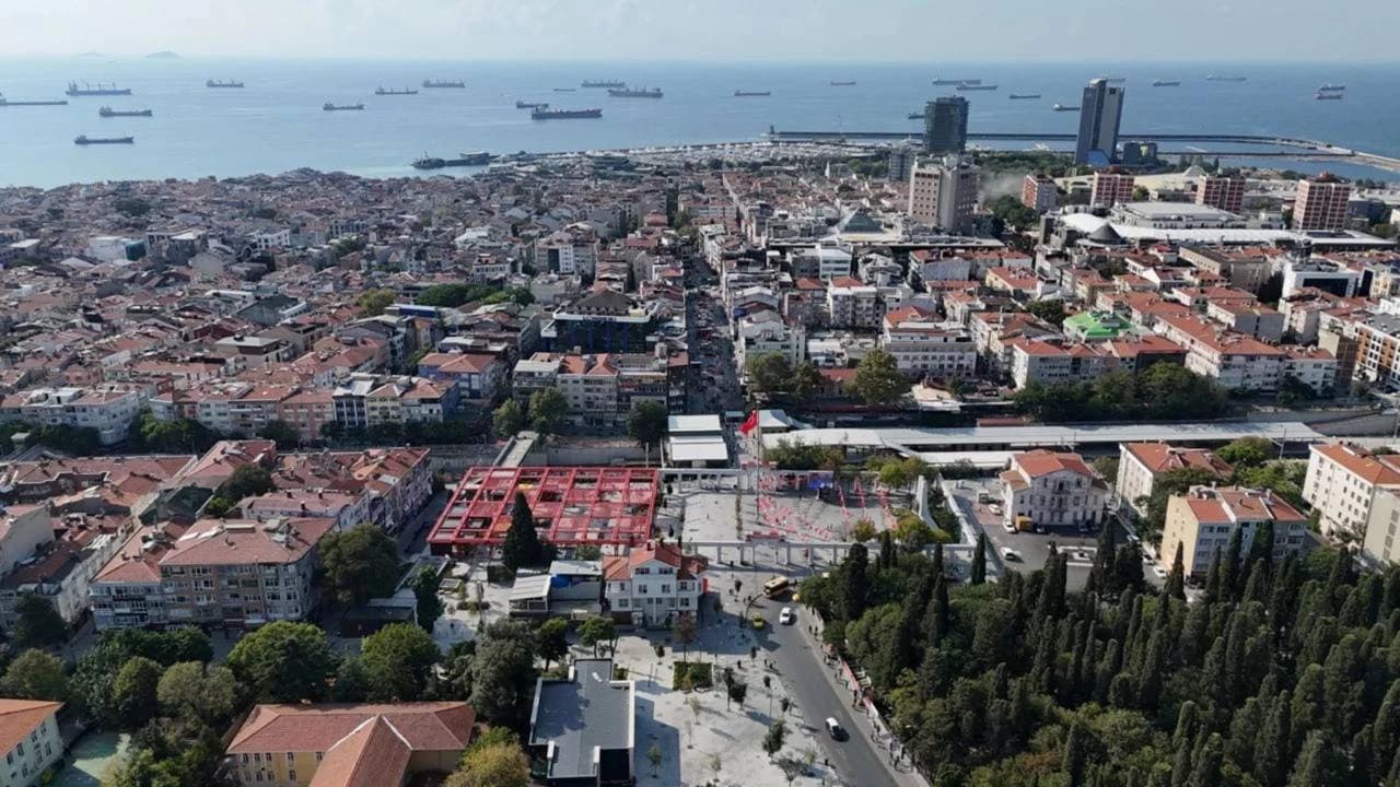 Aerial view showing buildings, streets, green spaces, and the sea with ships in Bakırköy, Istanbul.
