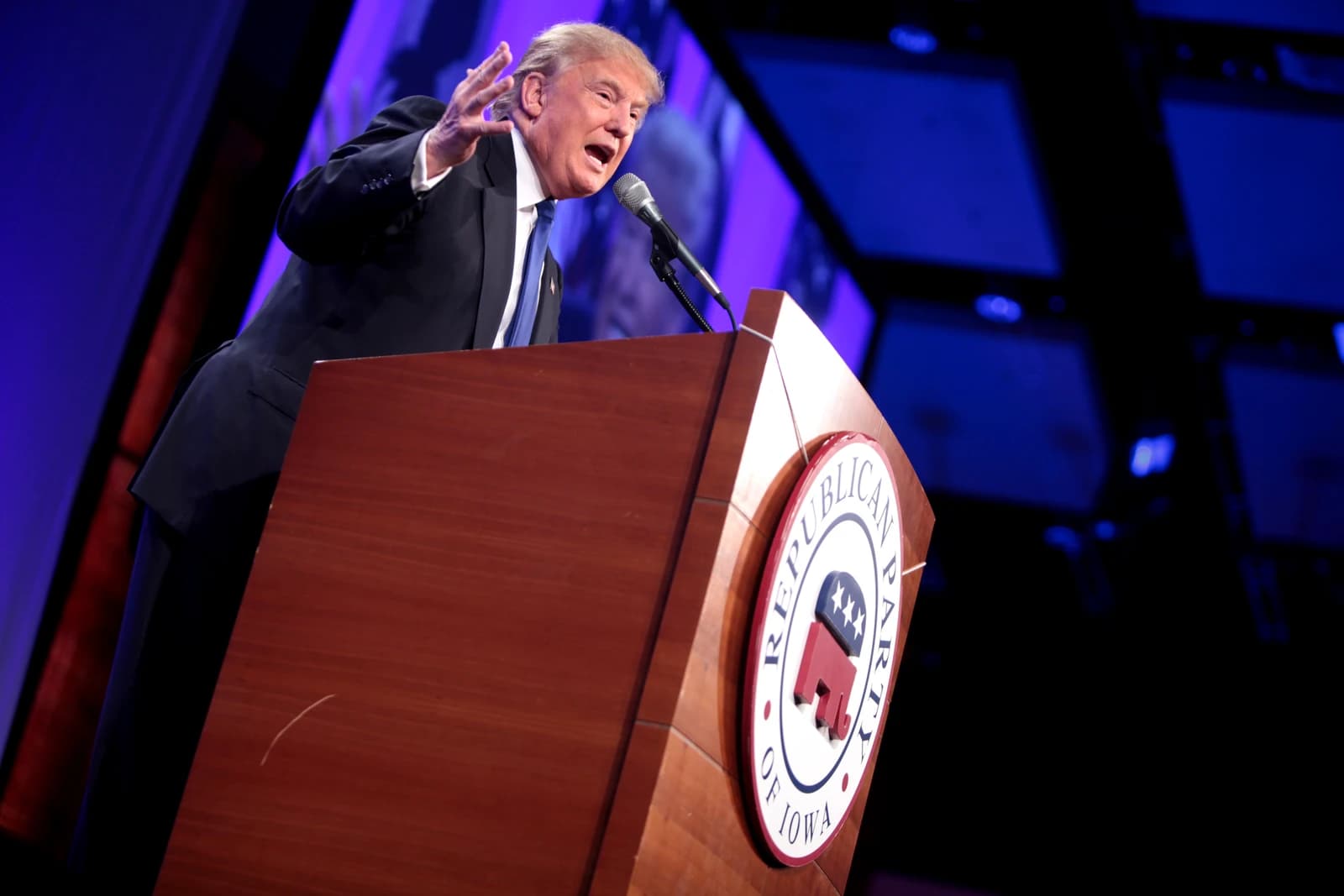 Donald Trump speaking at a podium with a microphone.