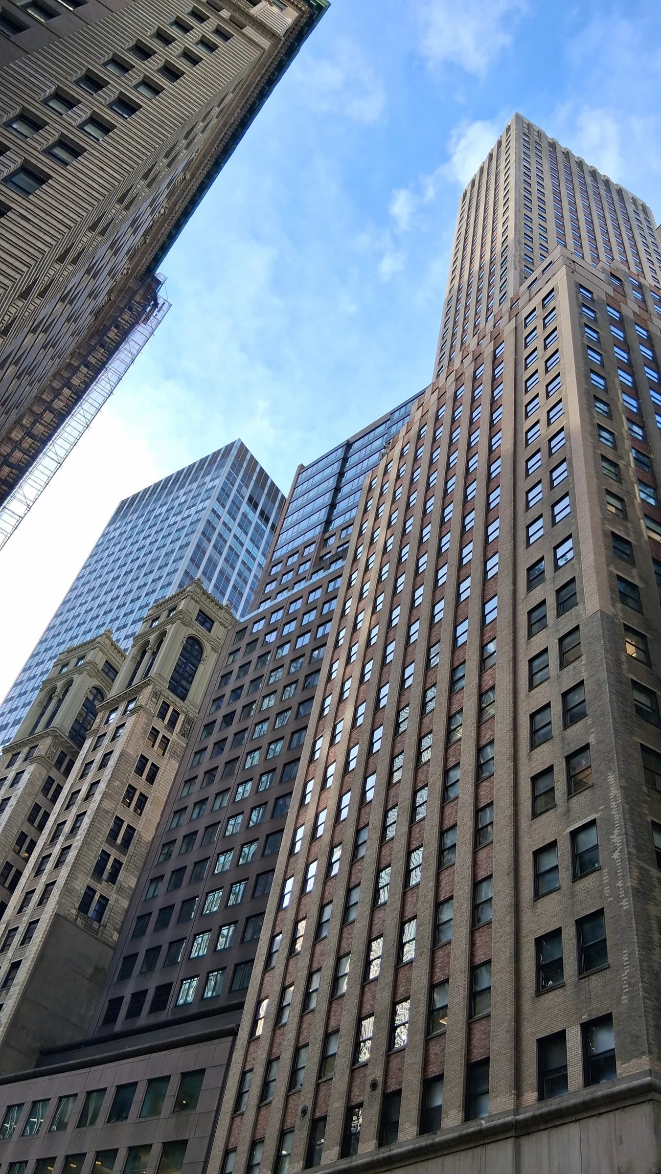 Tall office buildings in a financial district under a blue sky.