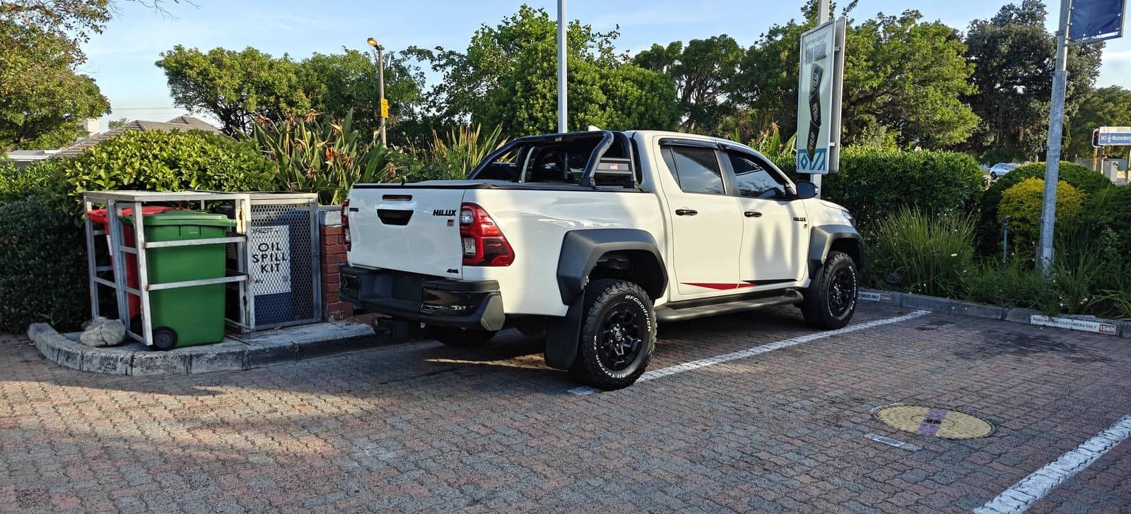 A white Toyota Hilux GR Sport pickup truck parked on a paved lot.