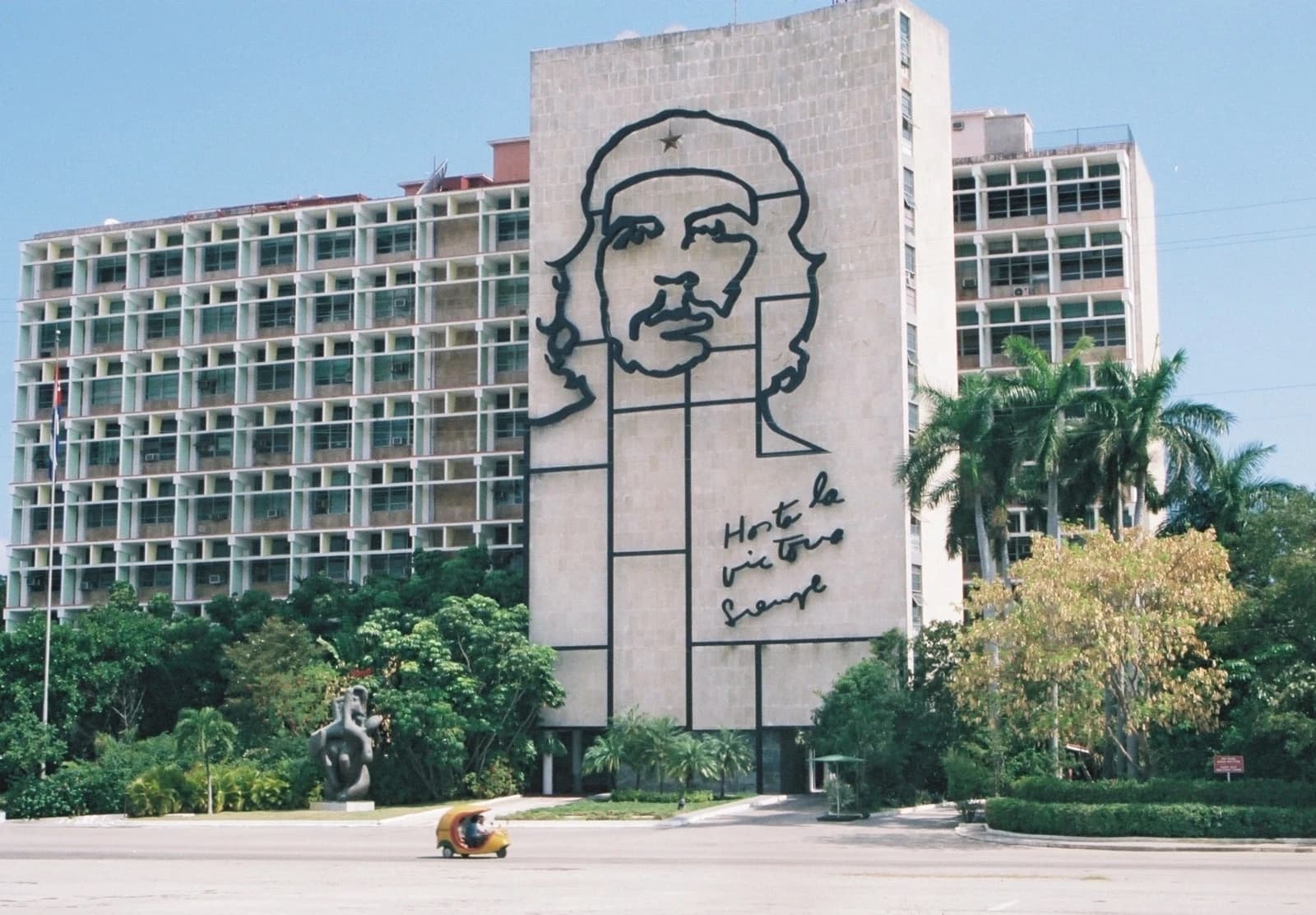 Building in Havana, Cuba, with a large metal outline of Che Guevara's face and writing on its facade.
