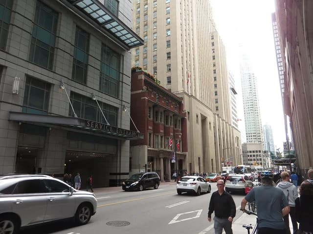 Street scene with the Bank of Nova Scotia Building on the right, traffic, and pedestrians.