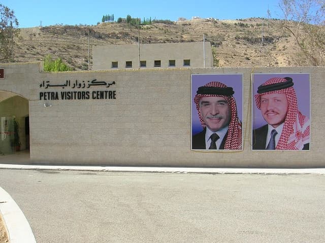 Petra Visitors Centre building with portraits of King Abdullah II and King Hussein on the wall.