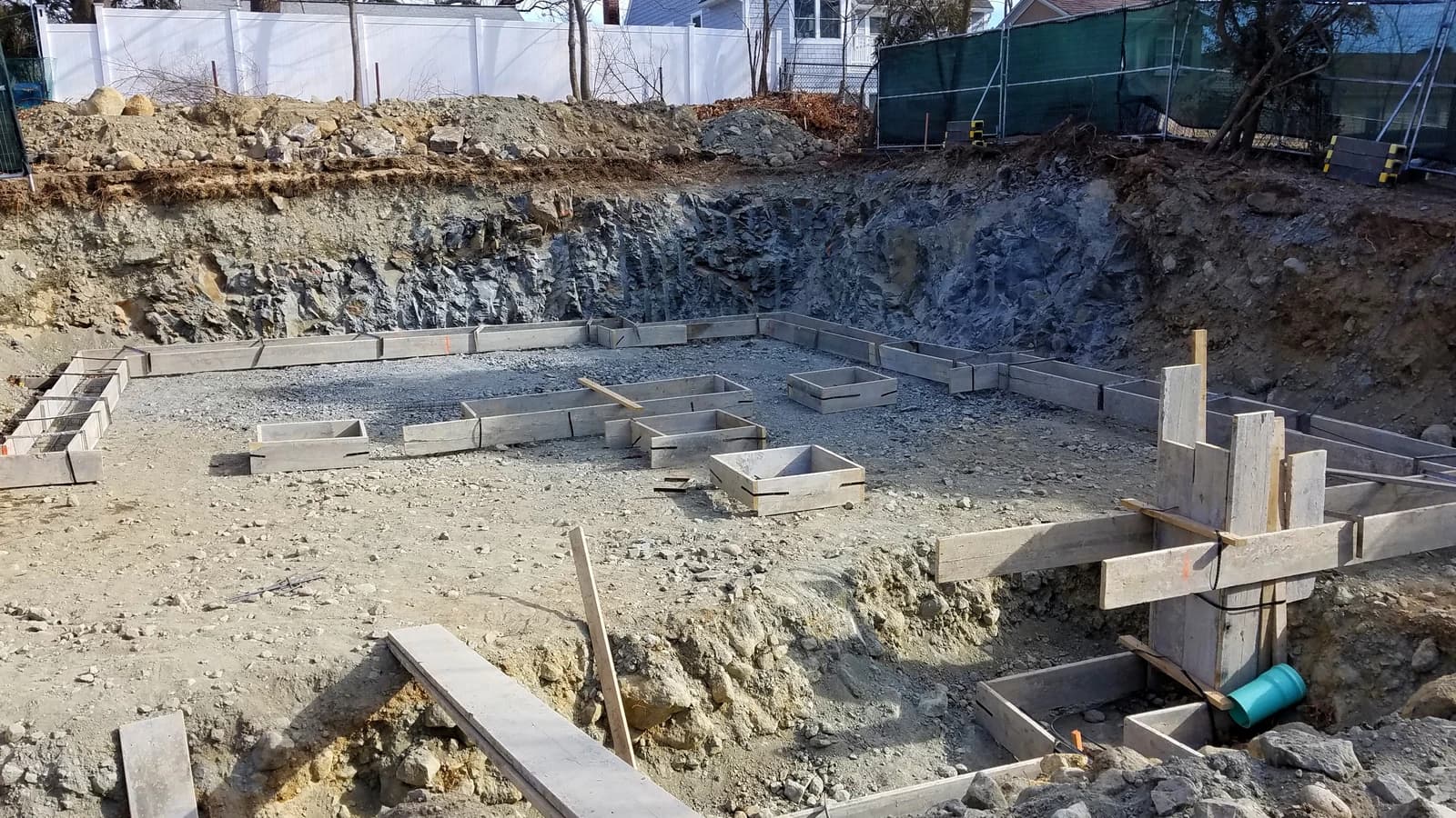 Wooden forms laid out for the foundation of a new house on a construction site.