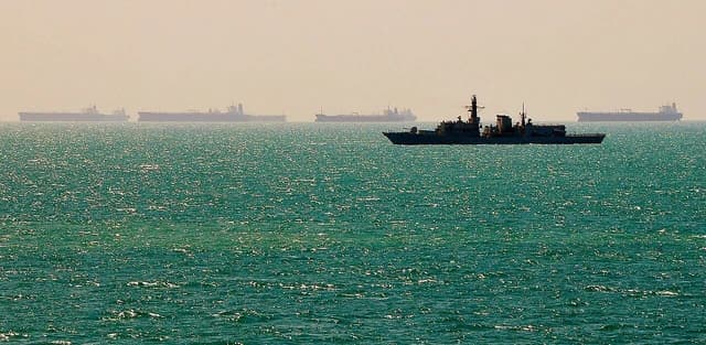Royal Navy frigate HMS Richmond patrolling waters near Al Basra Oil Terminal, Iraq, with merchant vessels.