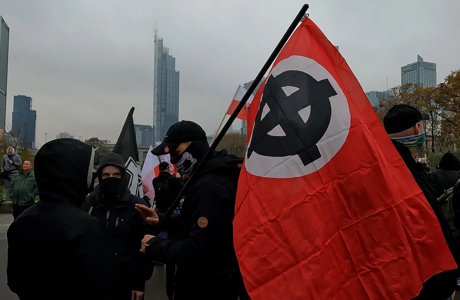 People gathered at a demonstration in a city in Poland, holding flags.