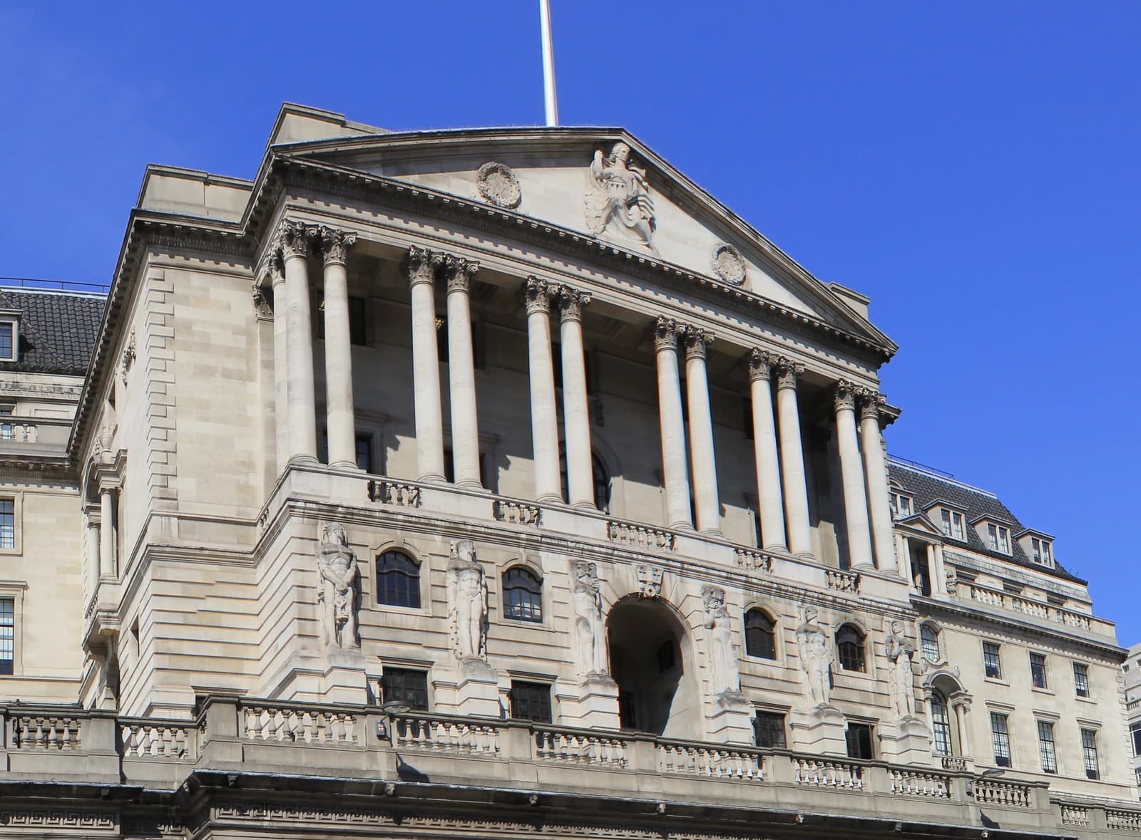 Exterior of the Bank of England building with columns and sculptures.