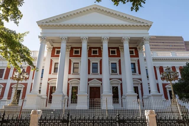 Parliament of South Africa building with large white columns and red brick facade.