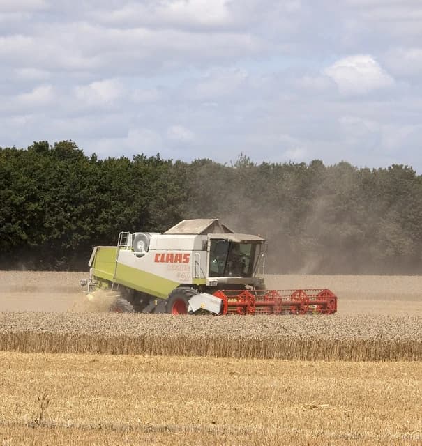 A Claas Lexion 440 combine harvester harvesting wheat in a field.