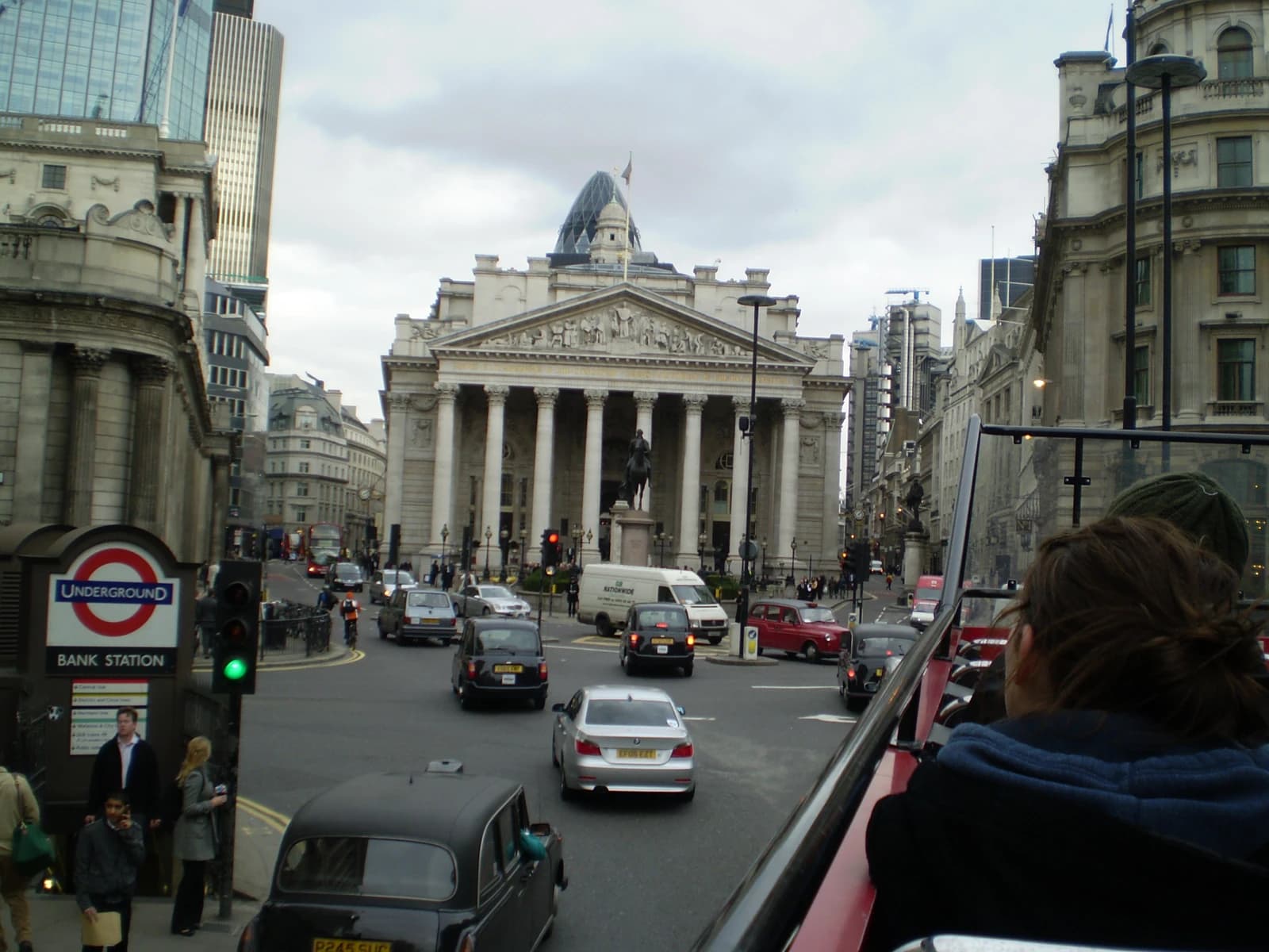 Bank Junction in London with the Royal Exchange and Bank of England on a cloudy day.
