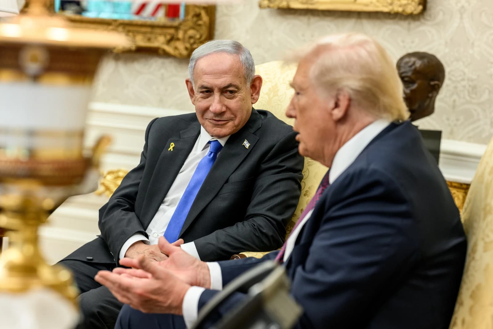 President Donald Trump and Israeli Prime Minister Benjamin Netanyahu sit together in a room.