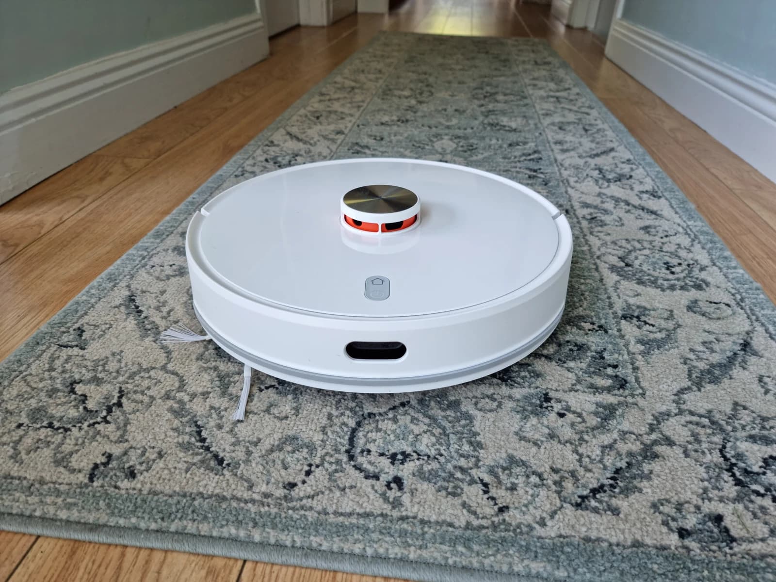 A white Xiaomi Lydsto robot vacuum and mop combo on a patterned rug.