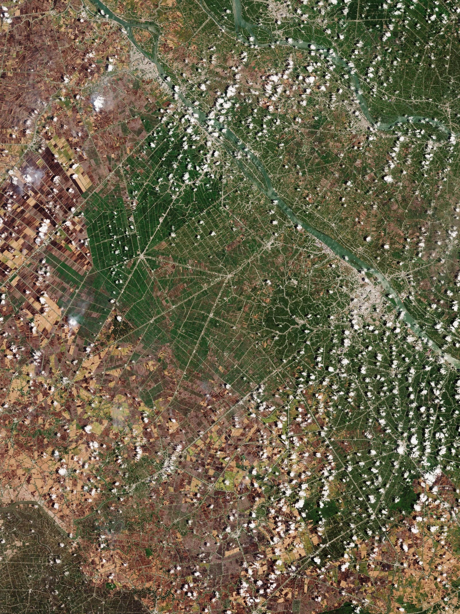 Satellite view of the Mekong Delta in Vietnam, featuring intricate waterways and patchwork agriculture.