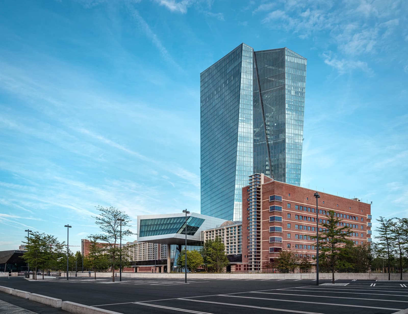 European Central Bank headquarters building in Frankfurt under a blue sky.