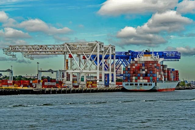 A container ship docked at Conley Terminal, being loaded or unloaded by cranes.