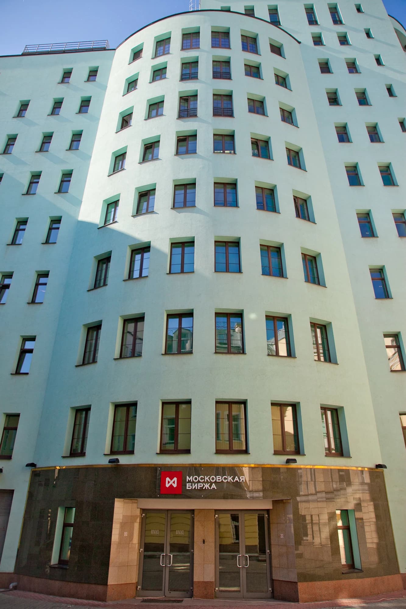 Exterior view of the Moscow Exchange building, showing the entrance and logo.