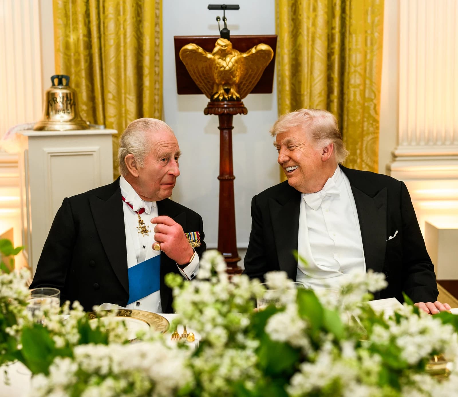 King Charles III and Donald Trump sitting at a table during a White House dinner.