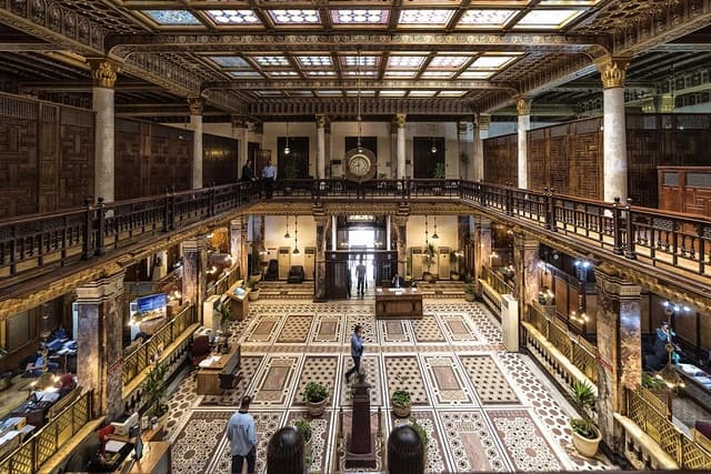 Grand, multi-level interior of the Main Bank of Egypt building, with ornate details.
