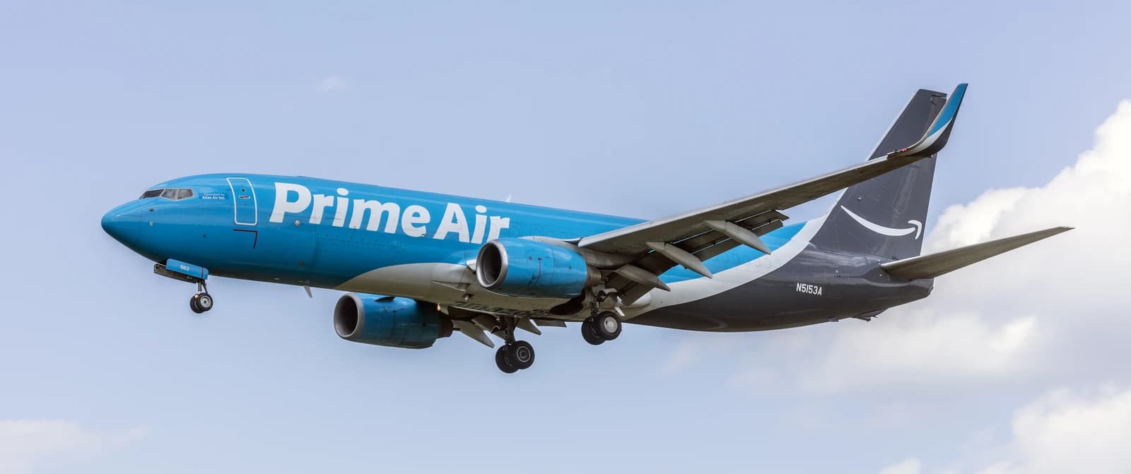 An Atlas Air Boeing 737-800 cargo jet in Prime Air livery flies through the sky.